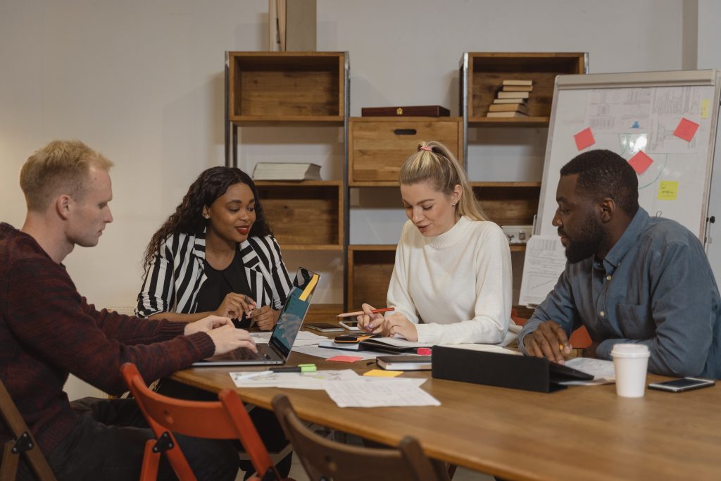 Four colleagues sitting around a conference table working together